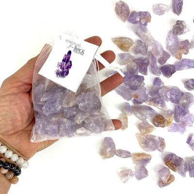 Amethyst Stones - Tied & Tagged in an Organza Bag in a hand for size