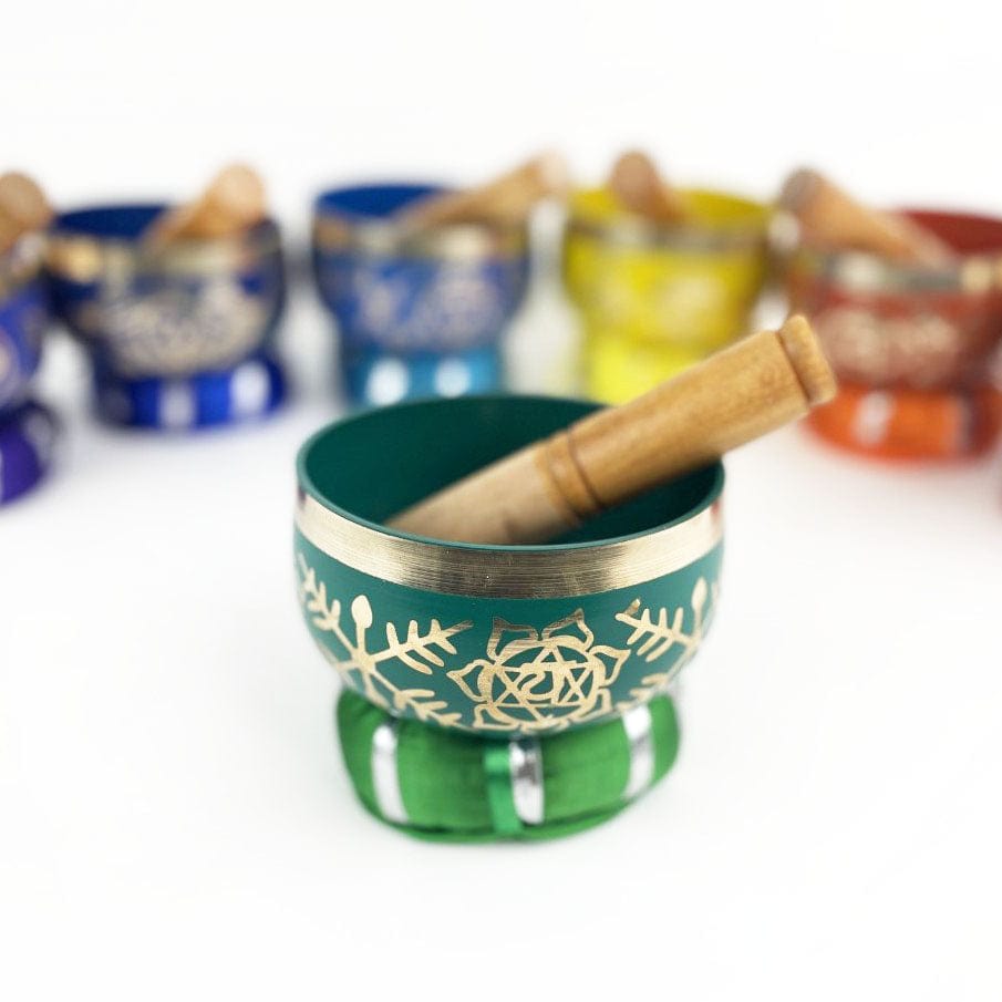 7 Chakra Colorful Singing Bowls, Pillows and Mallets with close up on green