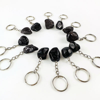 Tumbled Garnet Keychains laid out in a circle, shown at a side angle 