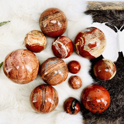 Red Jasper Polished Spheres of different sizes on black and white fur background