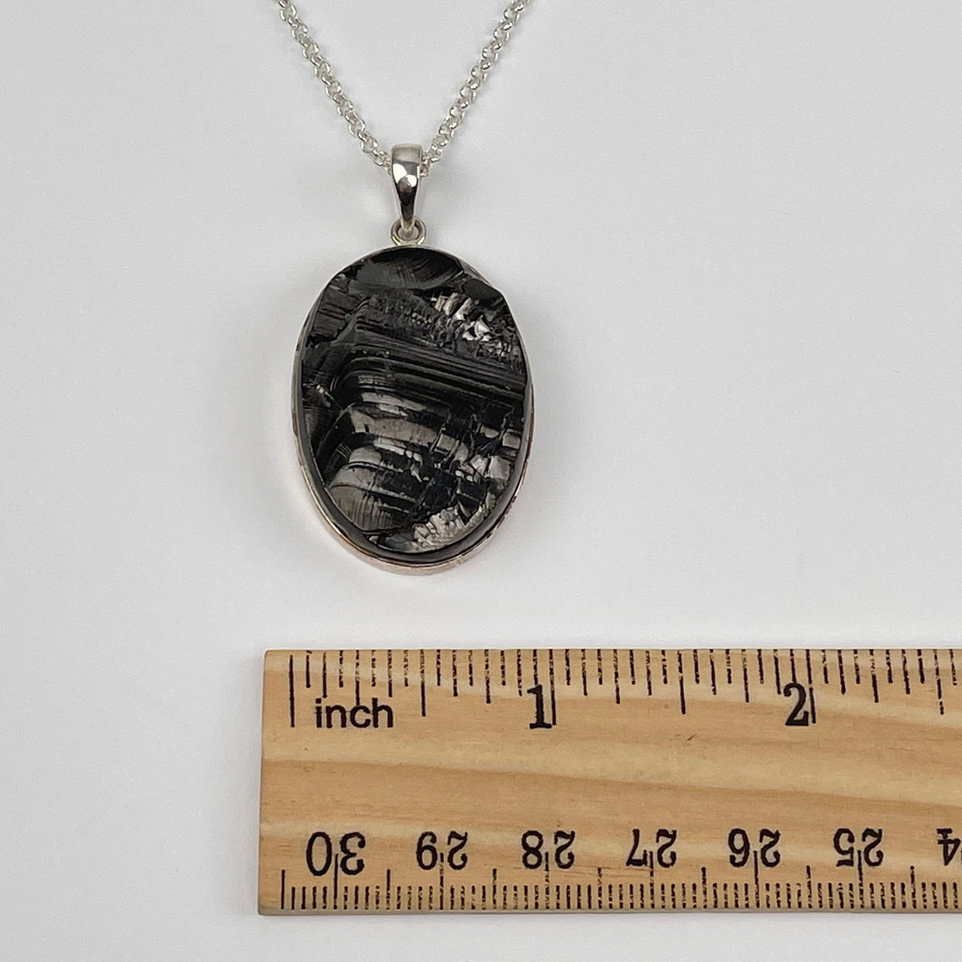 shungite pendant next to a ruler for size reference 