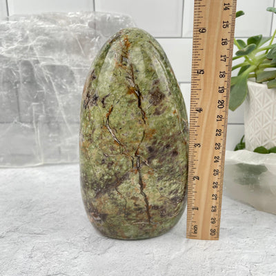 Green Opal Polished Cut Base next to a ruler for size reference 