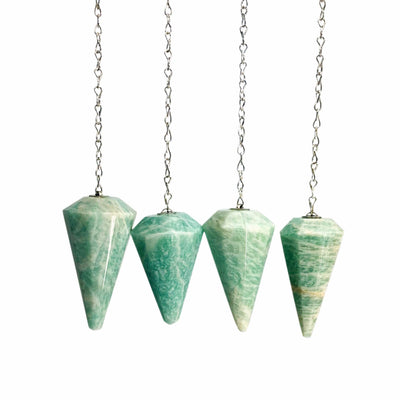 amazonite pendulums being displayed on a white back ground.