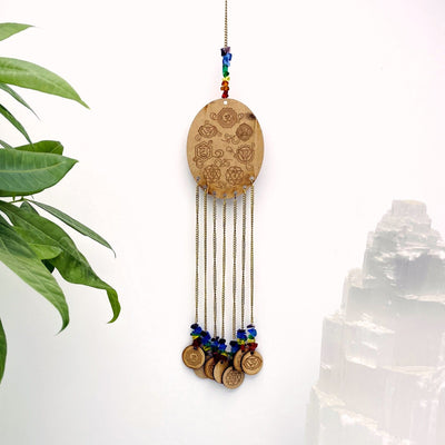 Engraved Wooden 7 Chakras hanged on white background.