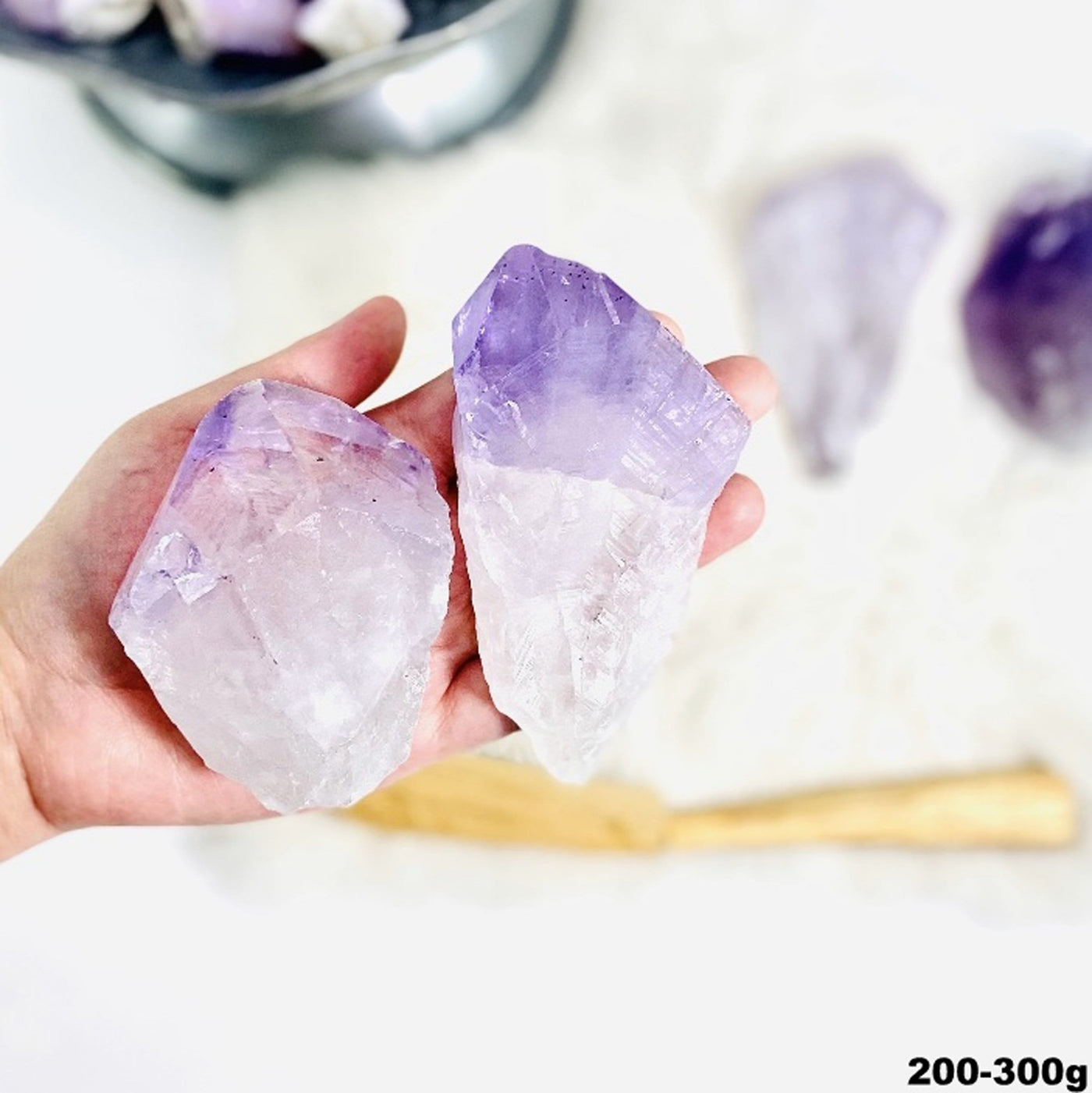 2 large amethyst points in a hand