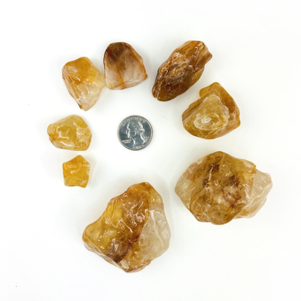 Golden Healer Quartz Polished Tumbled Stones around a quarter for size reference