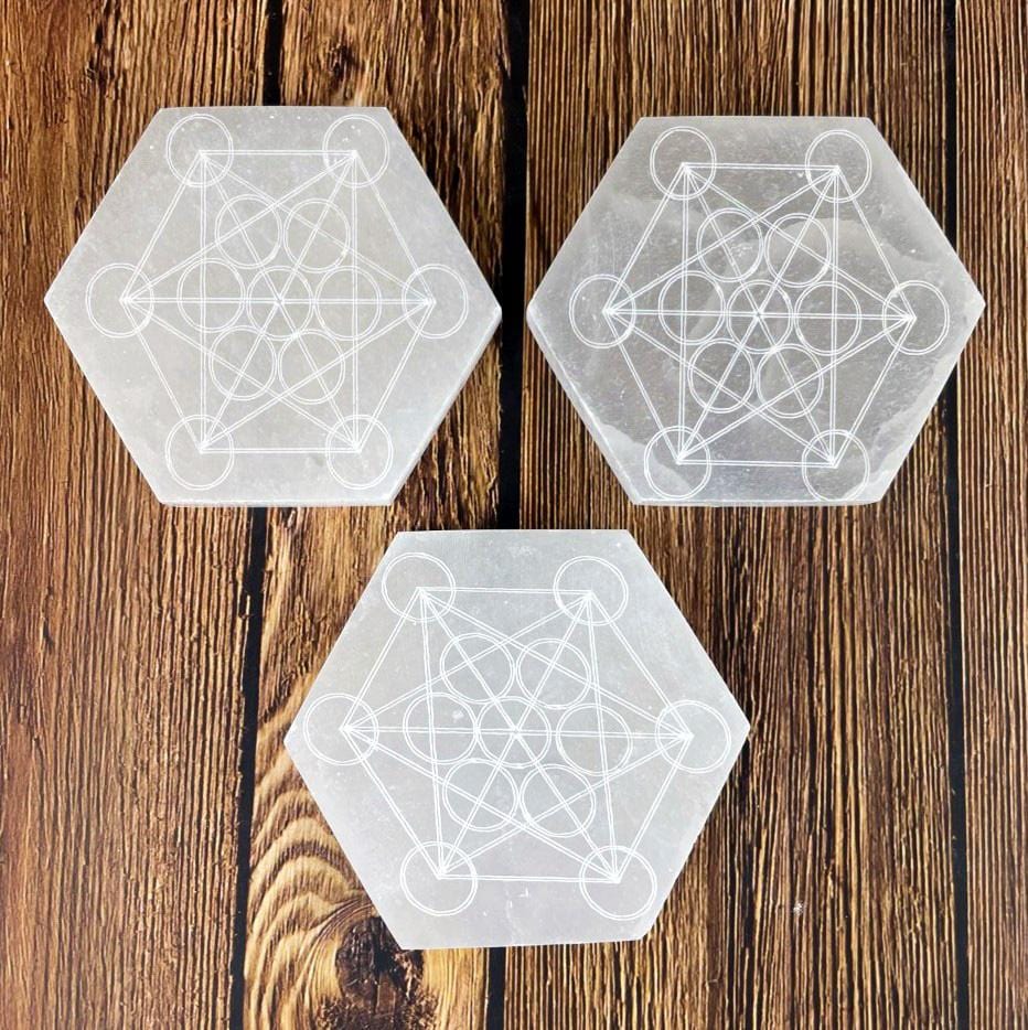 overhead view of three selenite hexagons engraved with metatron symbol for engraving details and possible variations 
