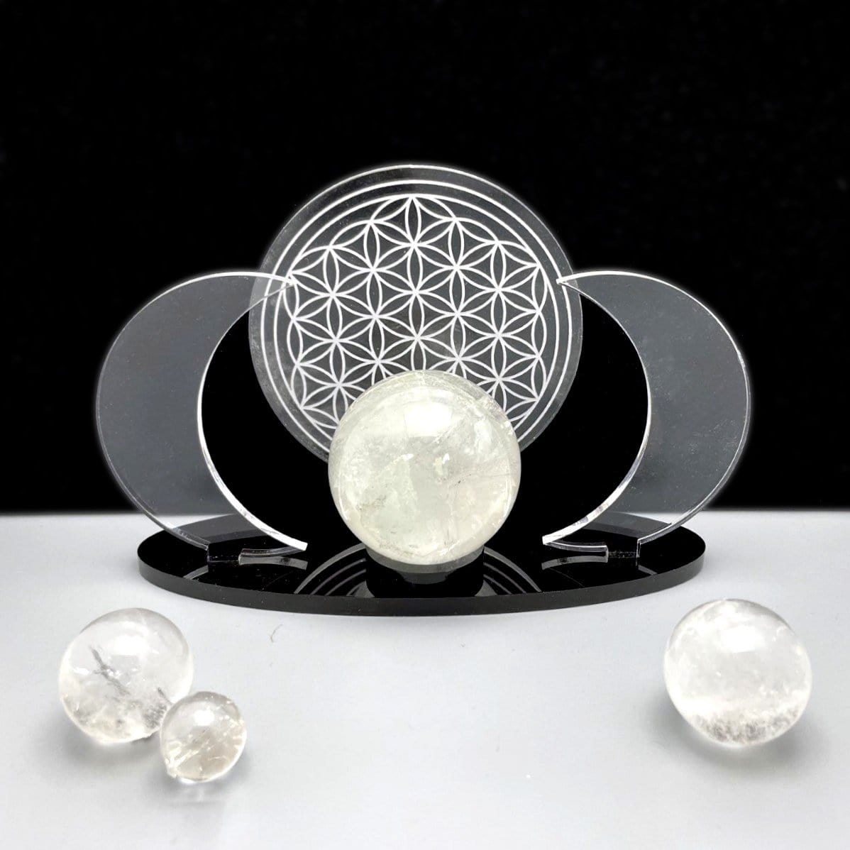 A front view of an Acrylic Sphere Holder Crescent Moons with Flower of Life holding a sphere. Surround spheres are for display.