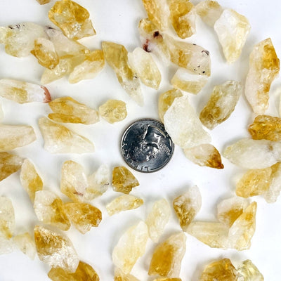 Citrine Stones - Golden Amethyst  spread on a table with a quarter for size