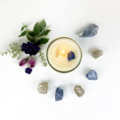 Top view of Release Intention Candle surrounded by crystals and flowers