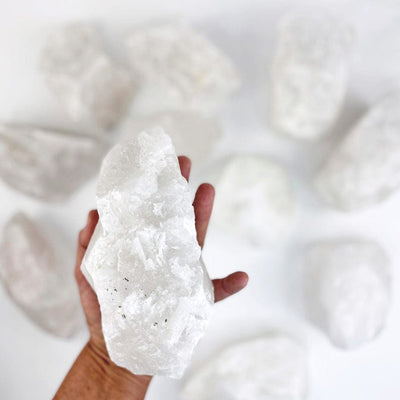 Crystal Quartz Chunk in a hand with others in background