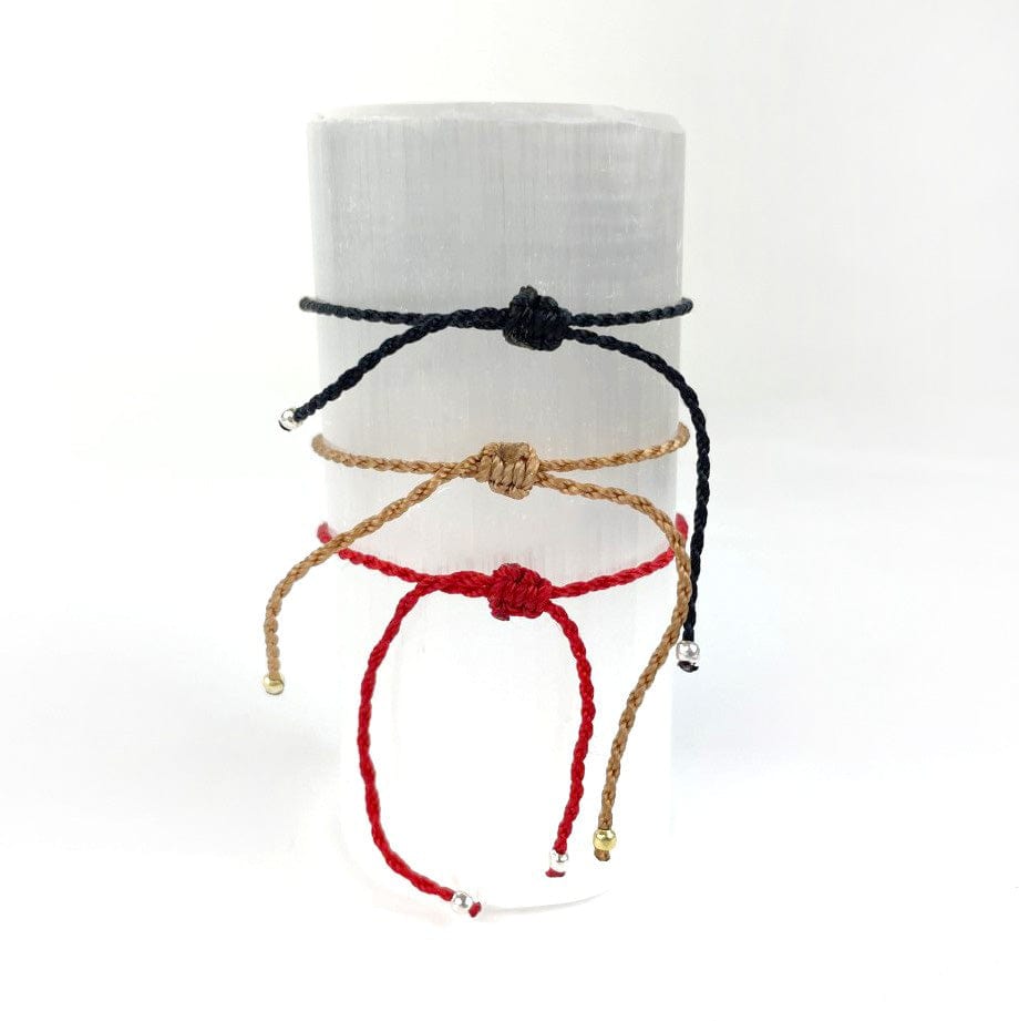 The back of the bracelets showing the special knot for adjusting to your wrist, in red, tan and black cording