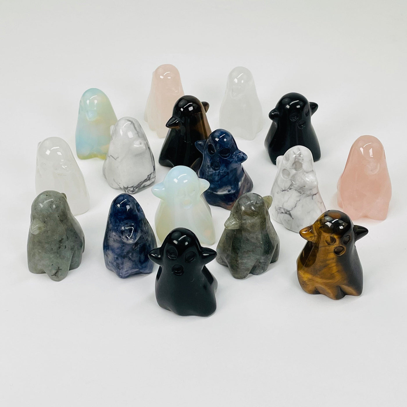 multiple carved gemstone ghost displayed to show the differences in the stone types and colors 