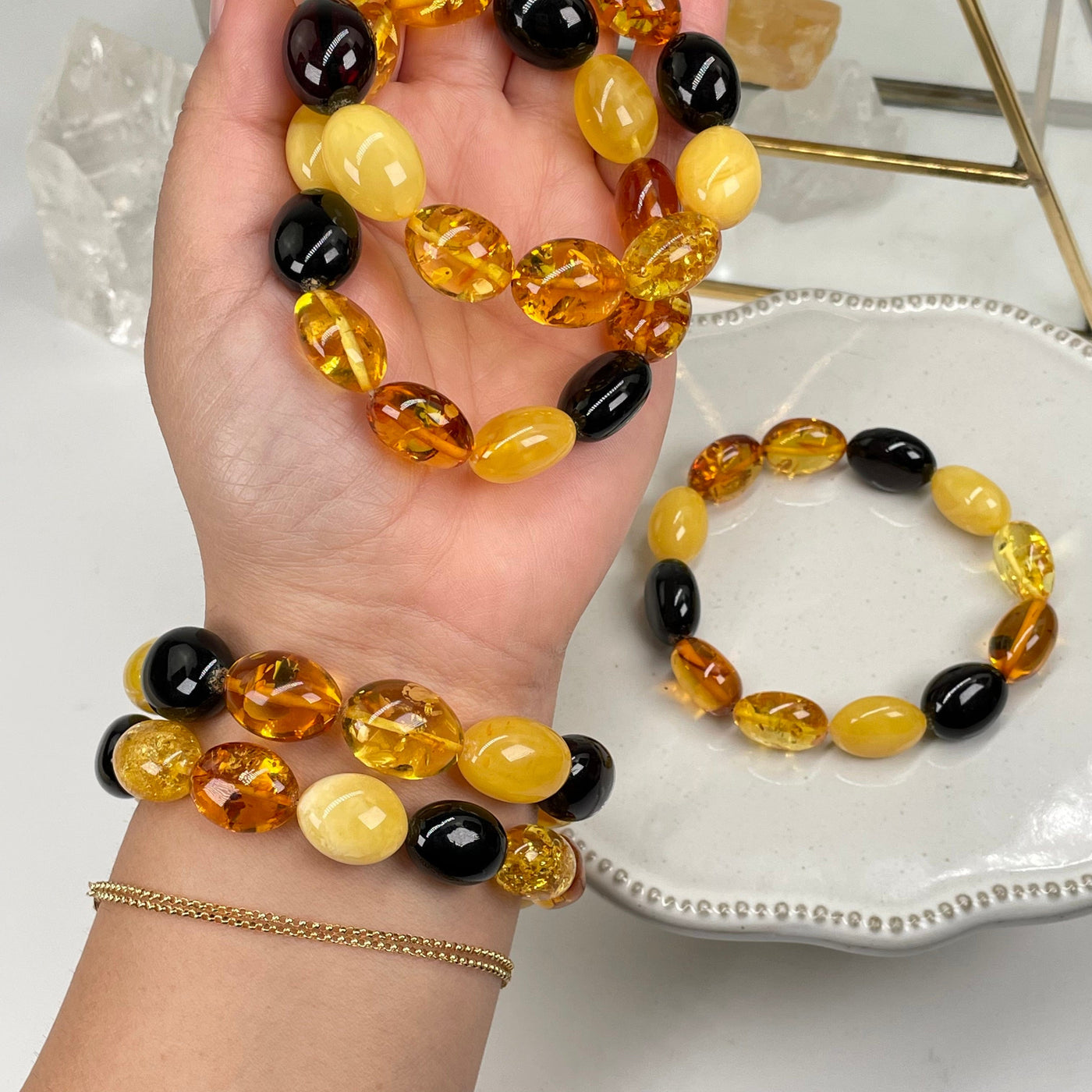 oval bead bracelets made of different toned amber beads in hand for size reference 