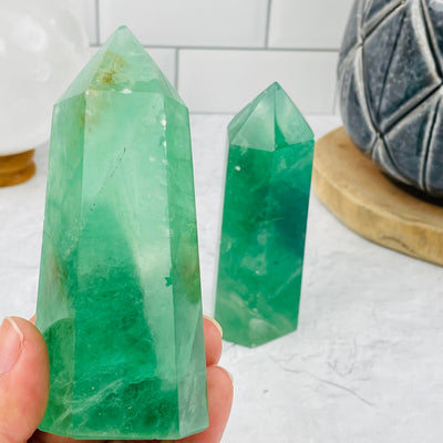 Green Fluorite Polished Point in hand for size reference 