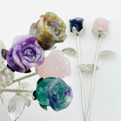multiple carved crystal roses displayed to show the differences in the crystal types 