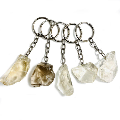 5 natural freeform citrine keychains with a silver plated key ring on a white background.