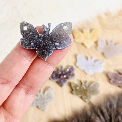 hand holding up druzy bumblebee with others blurred in the background
