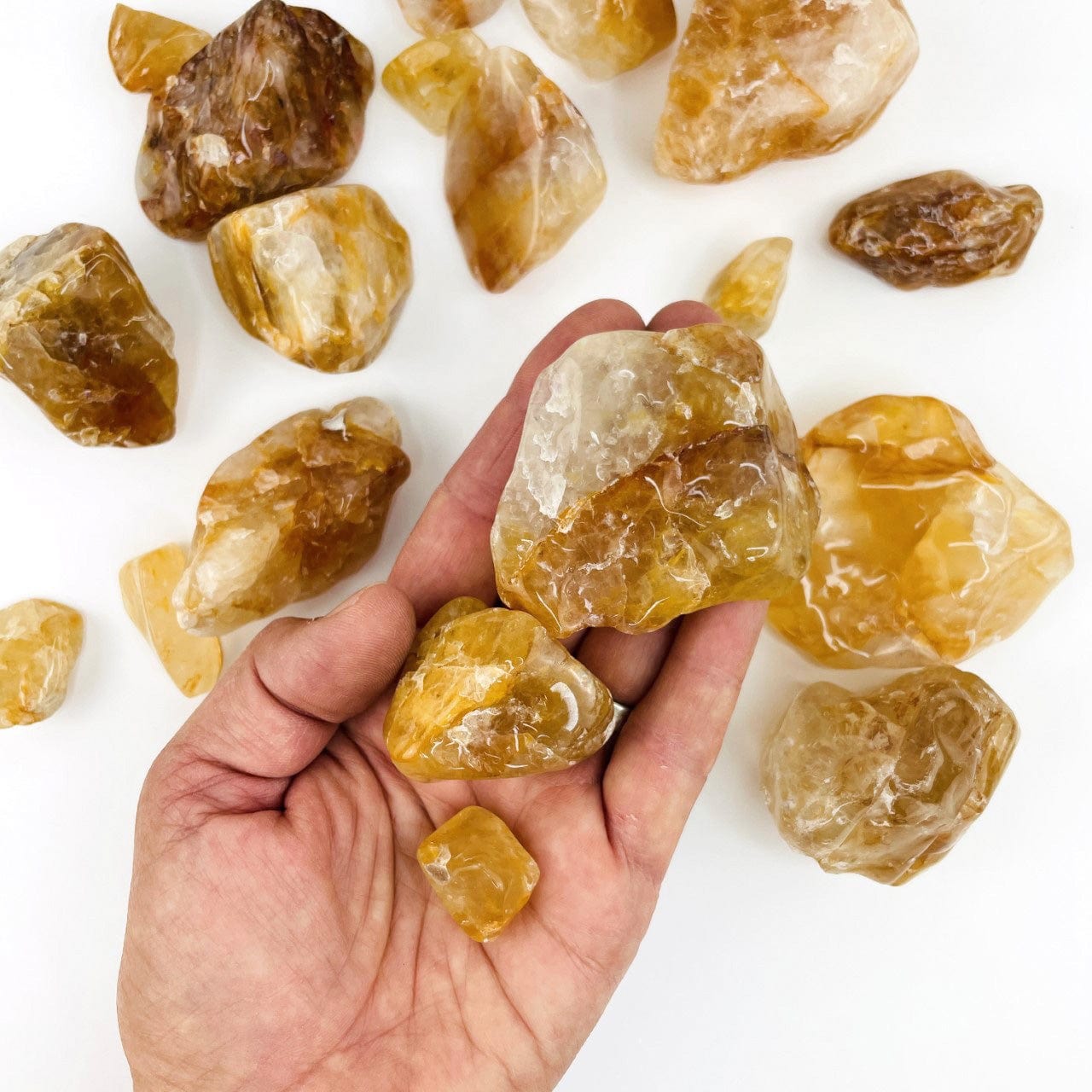 Golden Healer Quartz Polished Tumbled Stones with a few in a hand for size