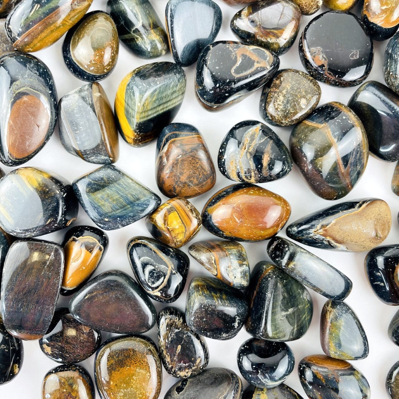 Blue Tigers Eye Polished Stones  spread out on a table
