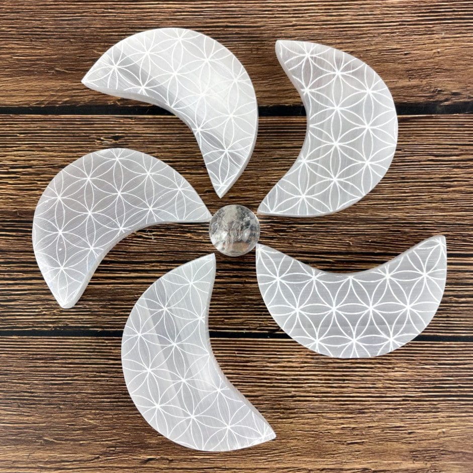 5 selenite moon with flower of life grids on a wood background arranged in a pin wheel design for style