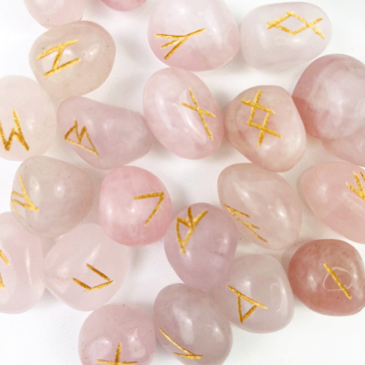 Rose quartz rune set up close of the gold engraving