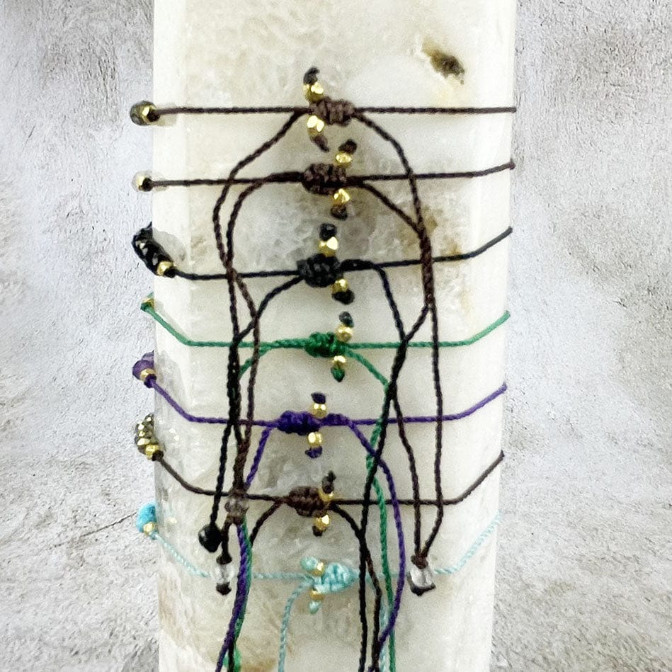 Gemstone Bracelet - Adjustable Cord with Gold Plated over Sterling Silver Beads one of each stone available, pyrite, moonstone, green onyx, labradorite, amethyst, black spinel, smoky quartz, and chinese turquoise on a stand showing back knot
