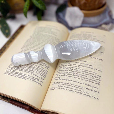angled view of selenite twisted handle knife with unalome engraving