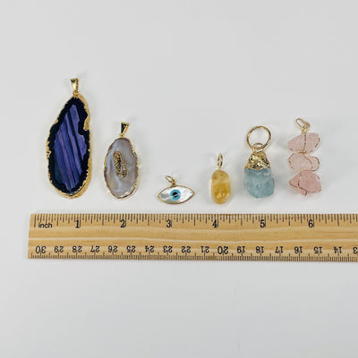 pendants next to a ruler for size reference