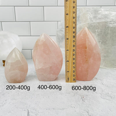 Rose Quartz Flame points sold by weight. They are displayed next to a ruler for size reference 