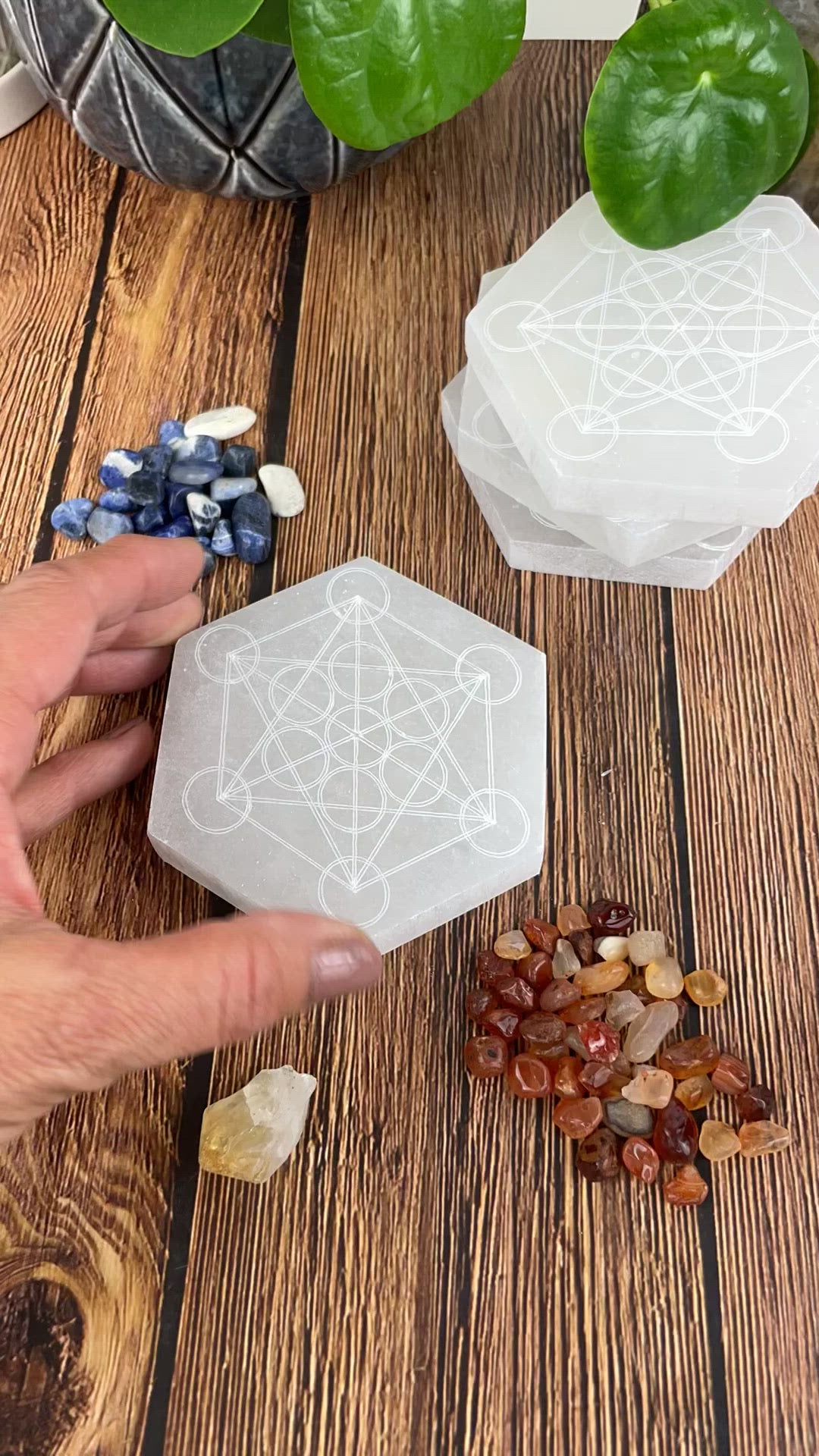 video of selenite hexagon engraved with metatron symbol with charging stones being arranged on engraving 