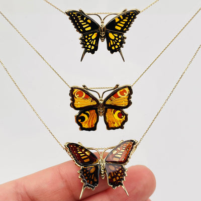 baltic amber butterfly necklaces displayed to show the differences in the patterns 