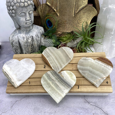 4 Aragonite Hearts with decorations in the background