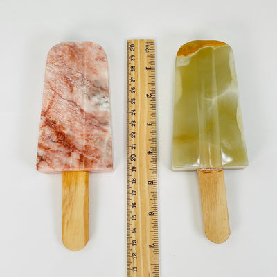 popsicles and stick next to a ruler for size reference 