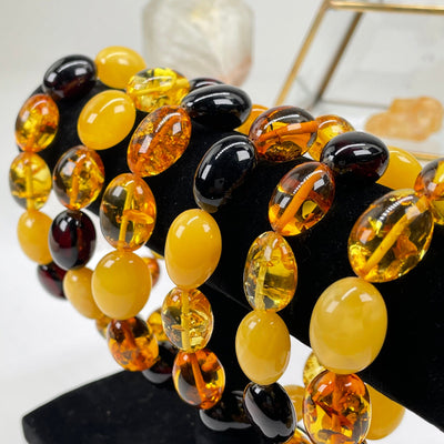 multiple  bracelets displayed to show the differences in the amber color shades 