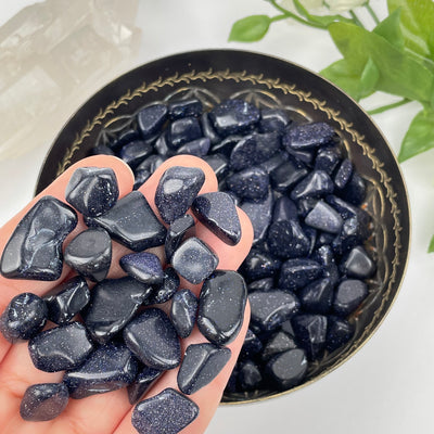 Blue Goldstone Tumbled Chips in hand for size reference 