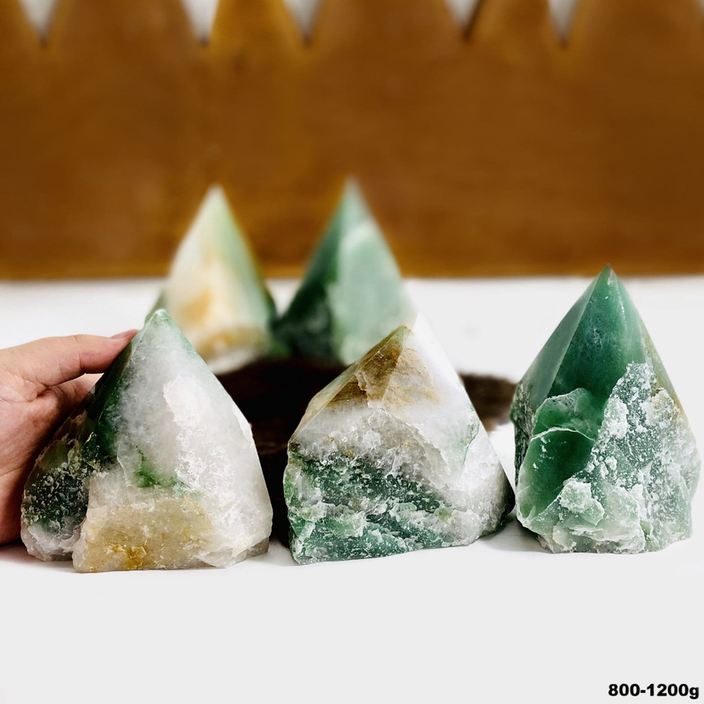 Assortment of green and white quartz semi polished points.  They are polished on top and rough along the sides.  They have a cut base so they can stand on their own.