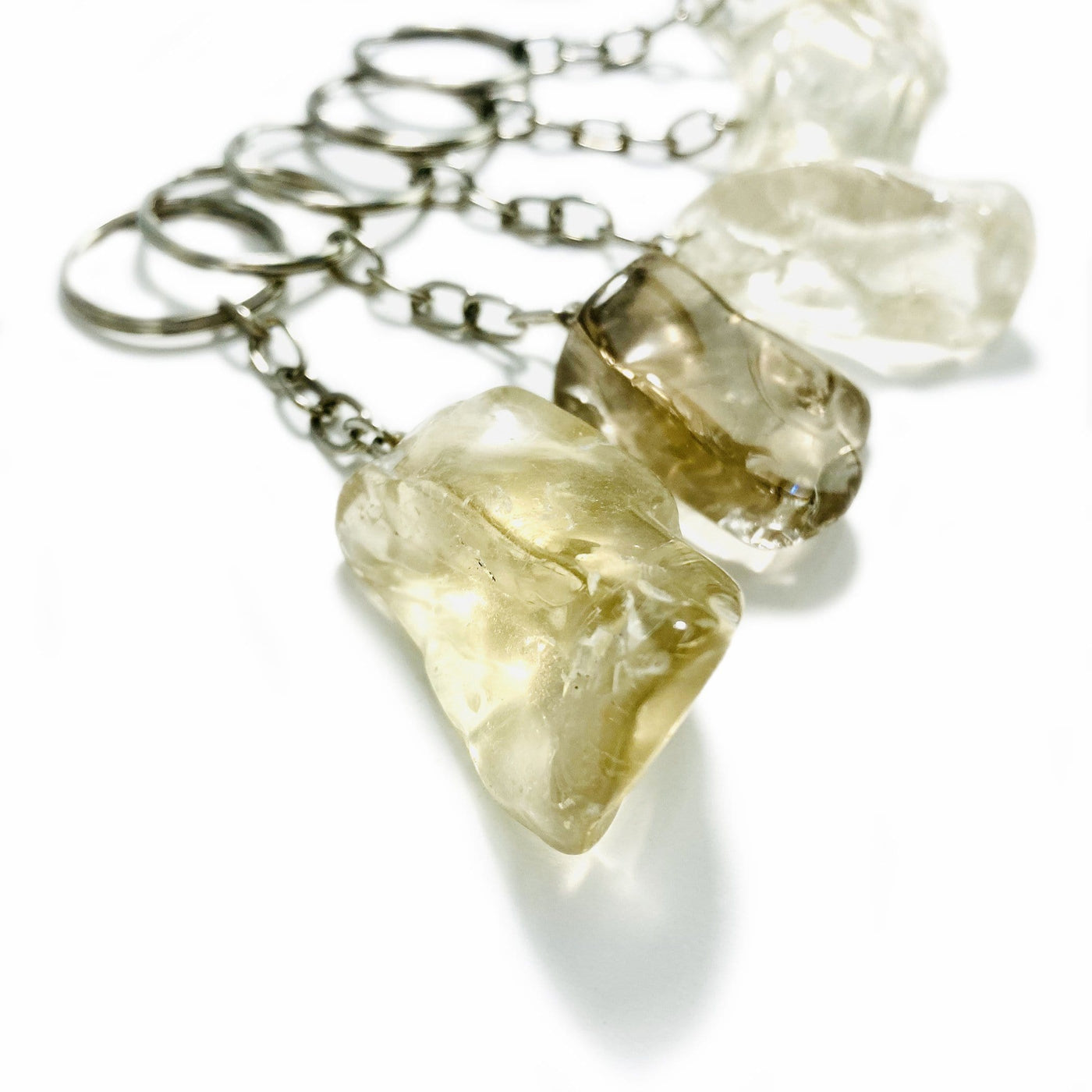 Close up of silver plated citrine key chains on a white background