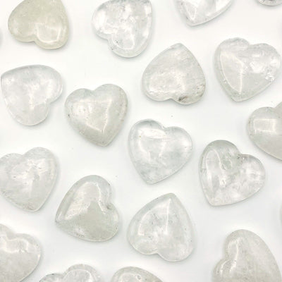 multiple crystal quartz heart shaped stones displayed to show the differences in the color shades 