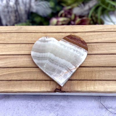 Aragonite Heart on wooden background with decorations