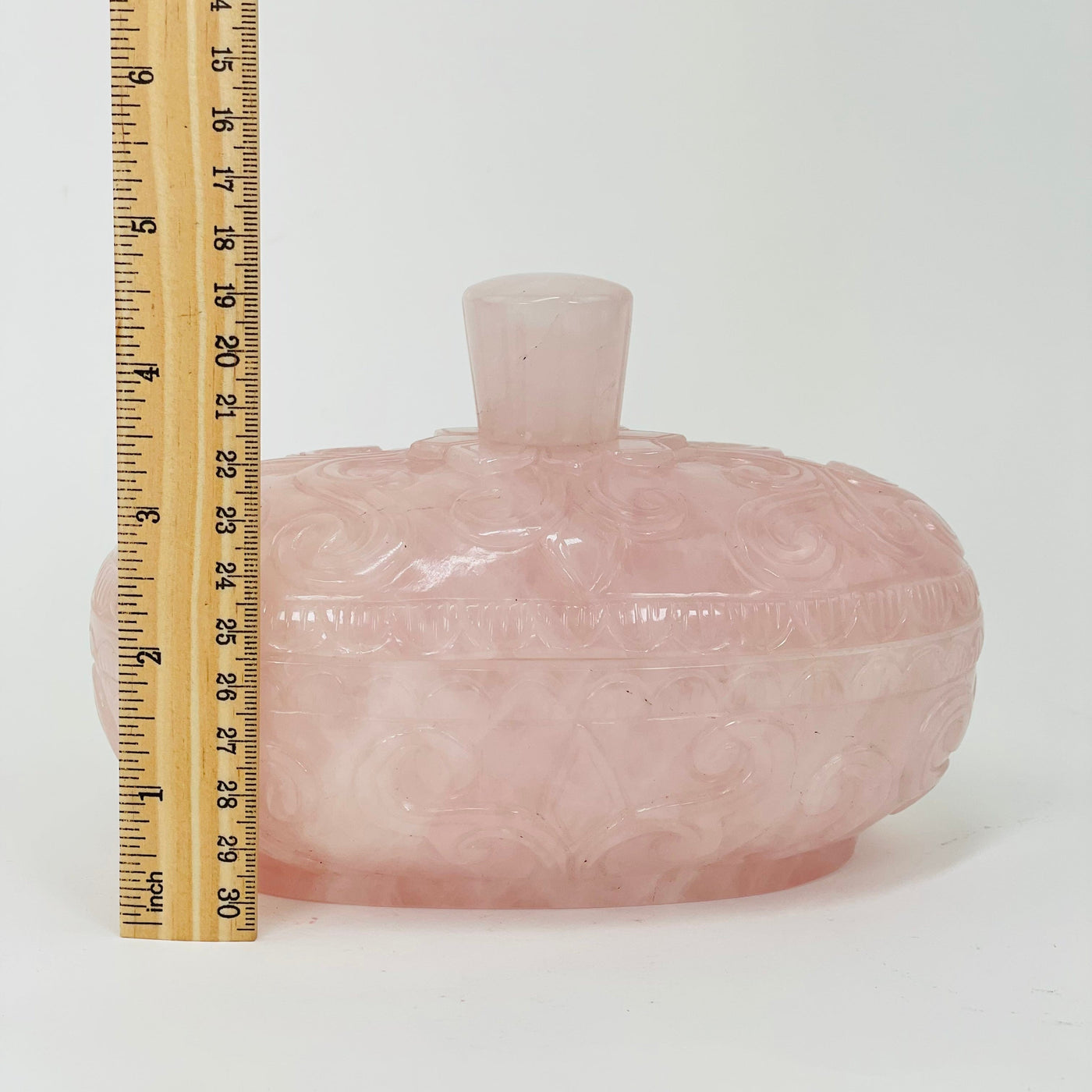 rose quartz bowl next to a ruler for size reference 