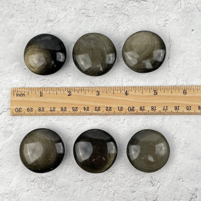 Polished Round Pocket Stones next to a ruler for size reference 