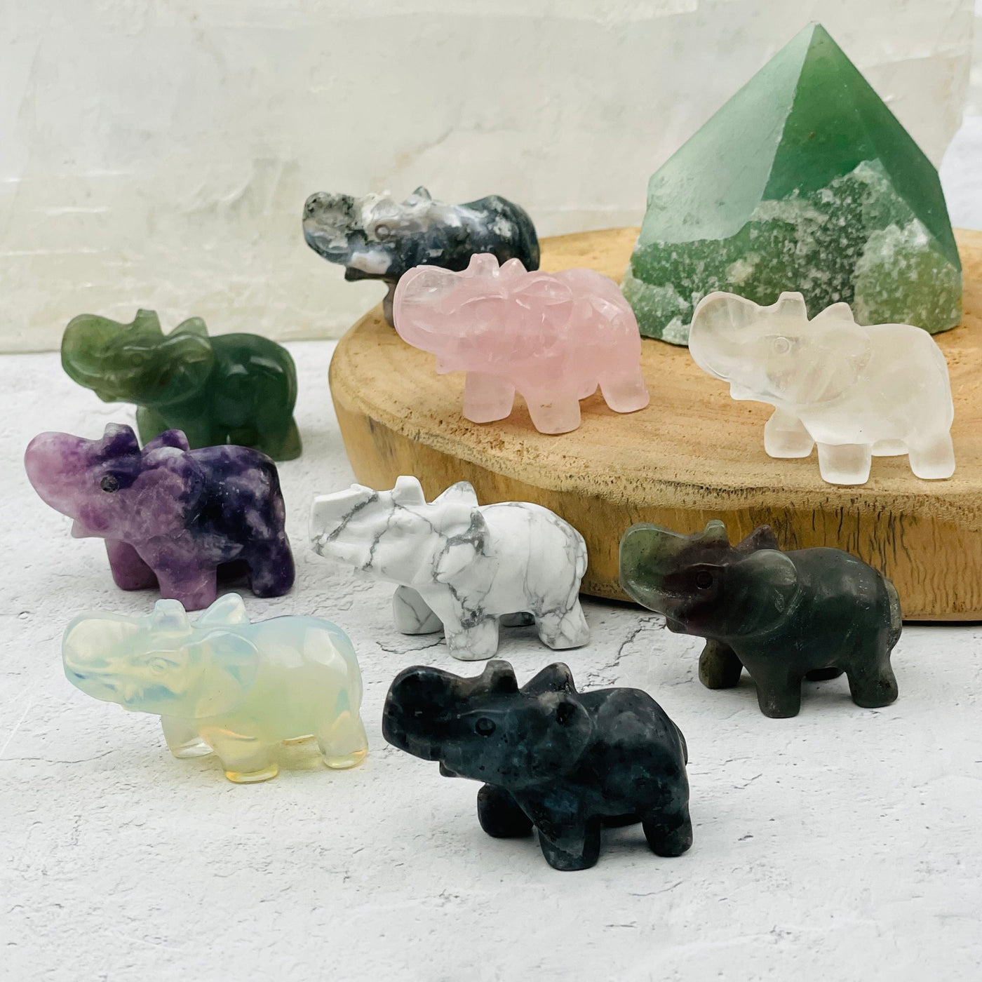 multiple gemstone elephants displayed to show the differences in the crystal types 