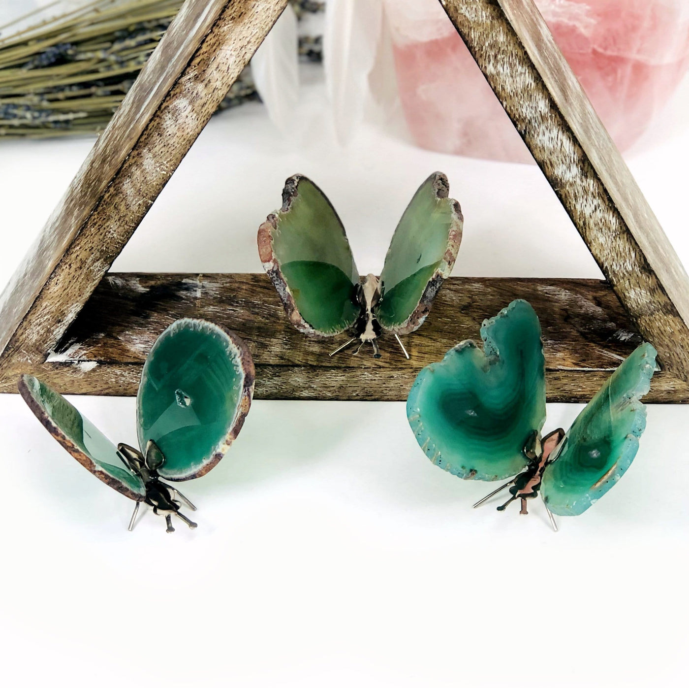 Green Agate Druzy Butterfly Stands in an alter with crystals and flowers.