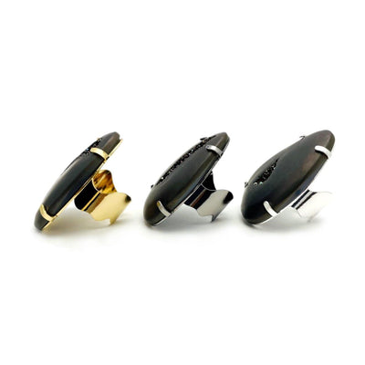 Side view of three black druzy rings on a white background.