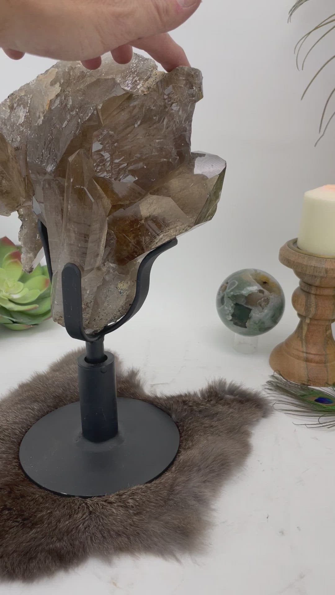 video of someone turning the smokey quartz cluster on its revolving metal base