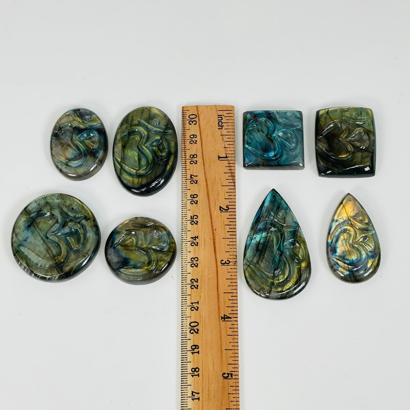 drilled labradorite cabochons next to a ruler for size reference 