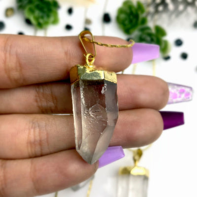 crystal point necklace in a hand