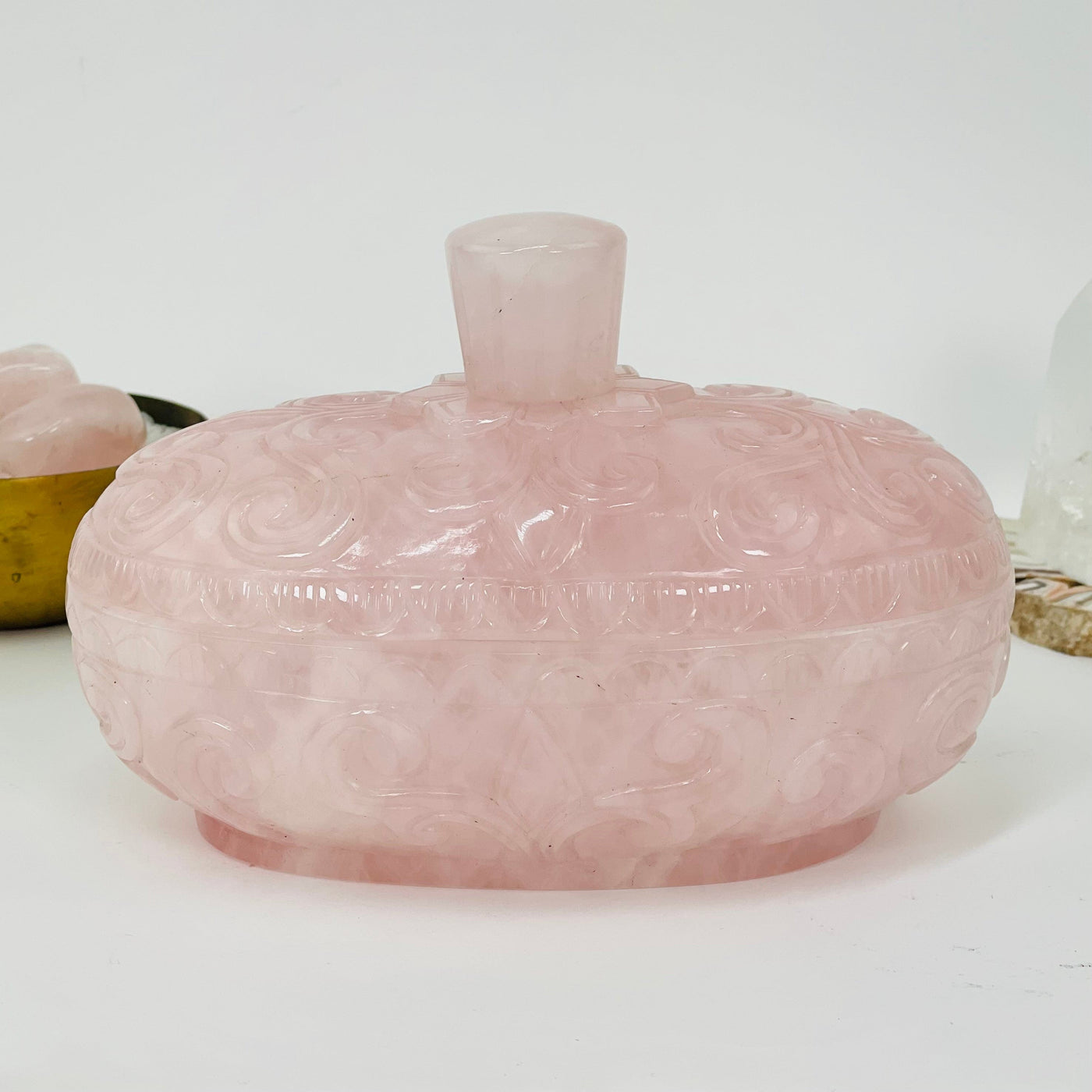 rose quartz bowl displayed to show the side carvings 