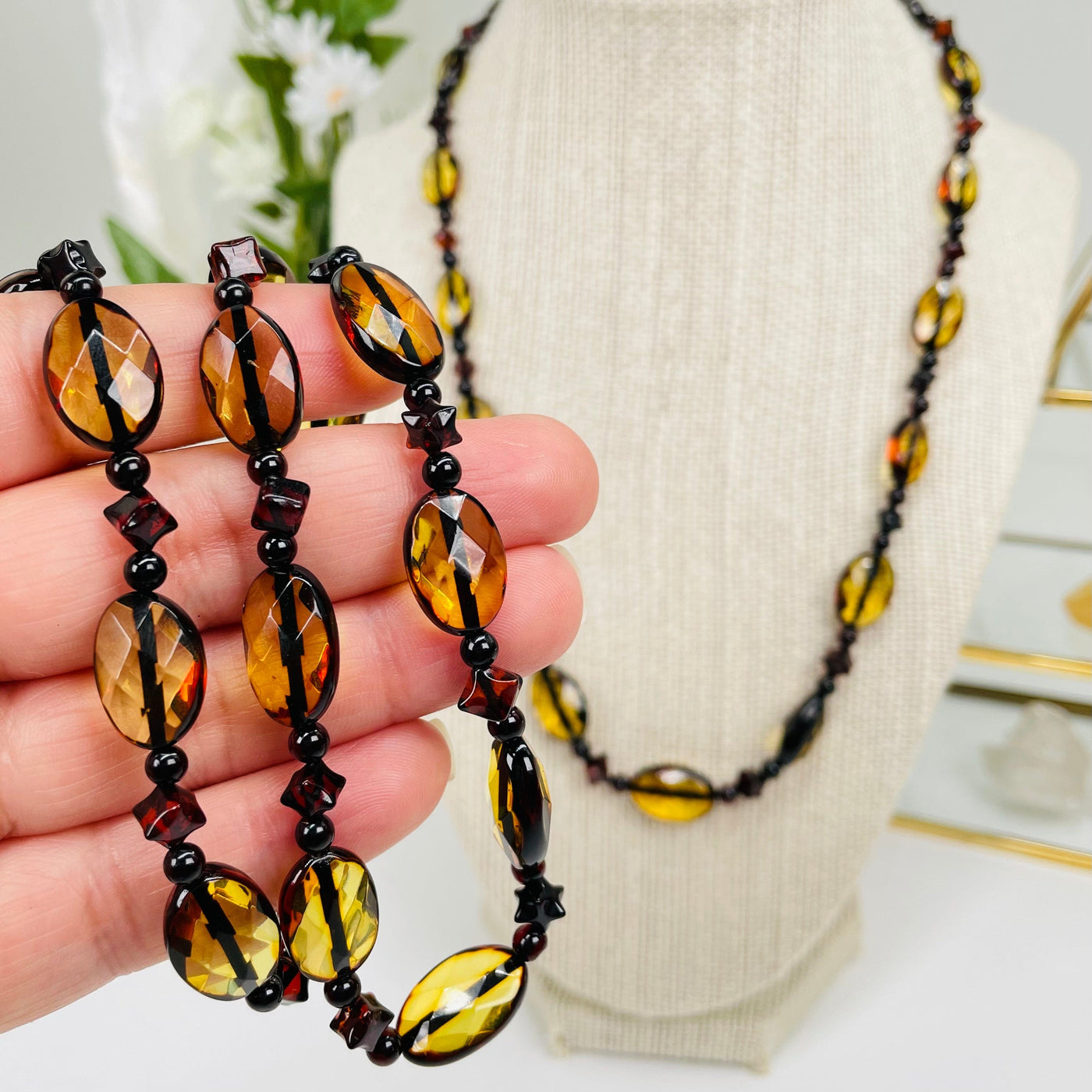 oval shaped bead amber necklace in hand for size reference 